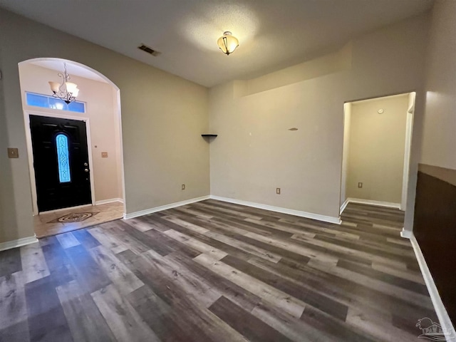 entrance foyer with a notable chandelier and dark wood-type flooring