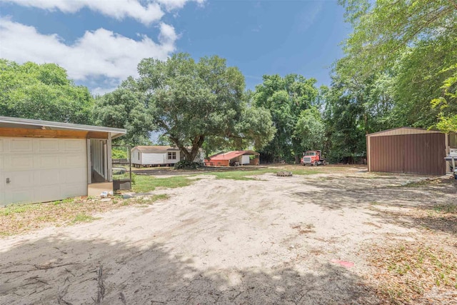 1424 Chemstrand Rd, Cantonment, FL 32533 - view of yard with an outdoor structure, a storage unit, and a garage