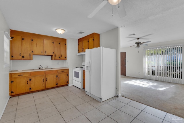 kitchen featuring ceiling fan, sink, white appliances, and light carpet