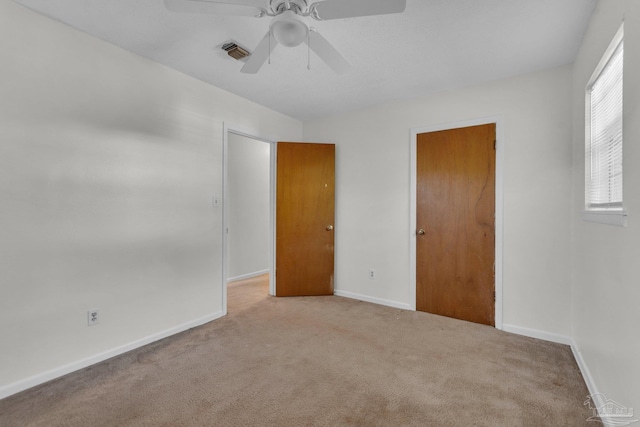 carpeted spare room featuring ceiling fan