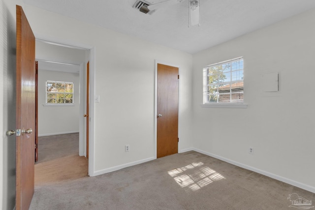 unfurnished bedroom with light carpet and ceiling fan