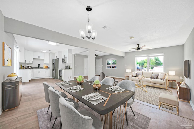 5686 Avondale Rd, Pensacola, FL 32526 - dining area featuring visible vents, ceiling fan with notable chandelier, light wood-style floors, and baseboards