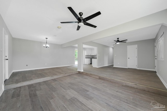 5686 Avondale Rd, Pensacola, FL 32526 - unfurnished living room with wood finished floors, ceiling fan with notable chandelier, and baseboards
