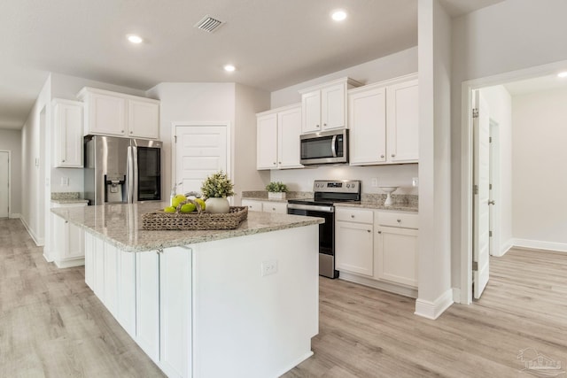 7822 Burnside Loop, Pensacola, FL 32526 - kitchen with appliances with stainless steel finishes, a kitchen island, white cabinetry, light wood-style floors, and recessed lighting