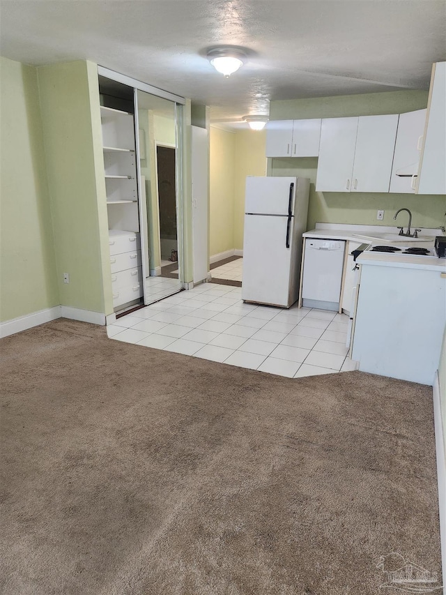 kitchen with white cabinetry, sink, light colored carpet, and white appliances