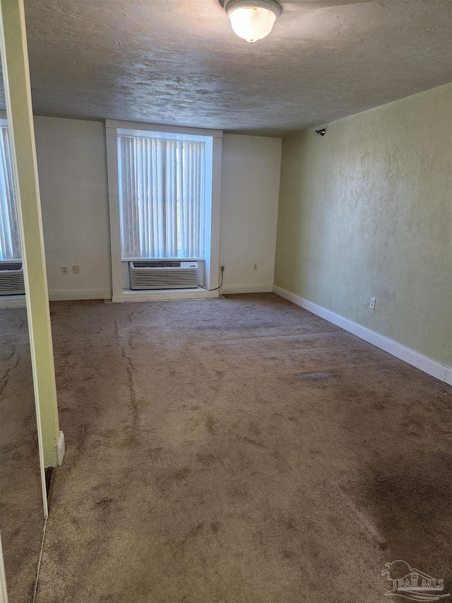 carpeted empty room with cooling unit and a textured ceiling