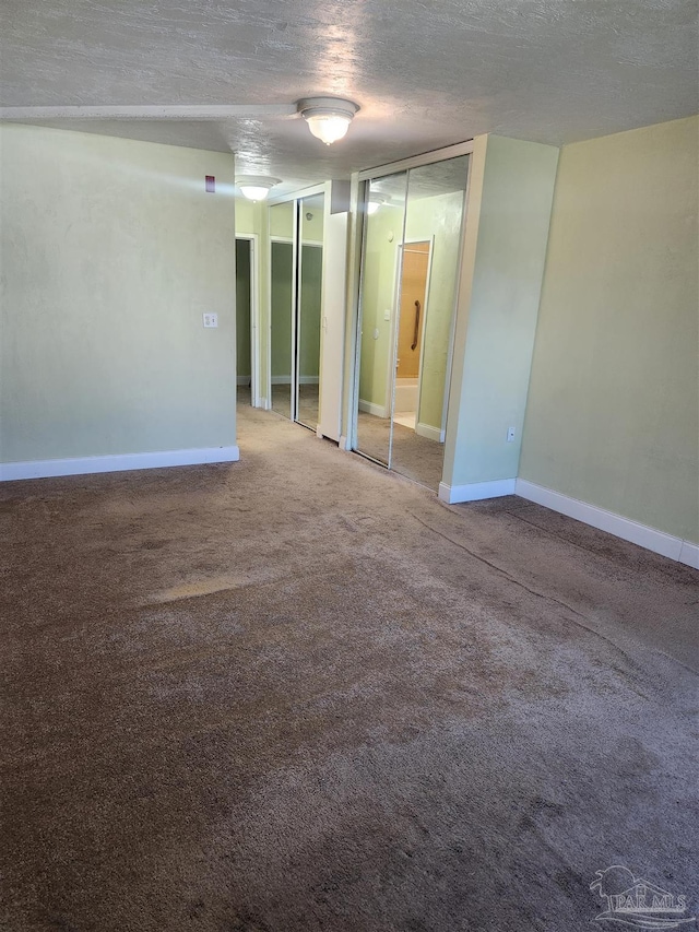 spare room with carpet and a textured ceiling