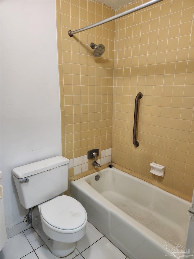 bathroom featuring tile patterned floors, tiled shower / bath, and toilet