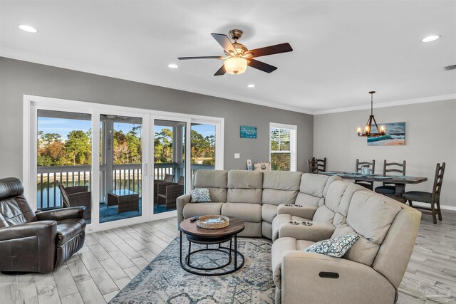 living room with ceiling fan with notable chandelier, light hardwood / wood-style flooring, and crown molding