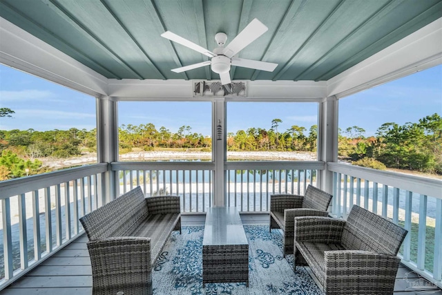 wooden terrace with ceiling fan and a water view