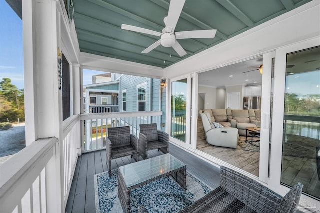 sunroom featuring beamed ceiling and ceiling fan