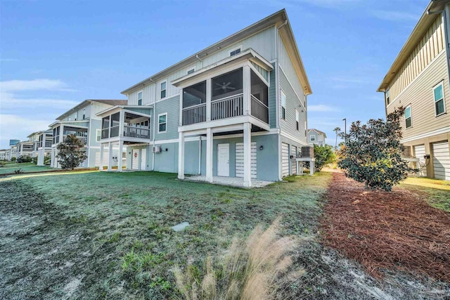 rear view of house with a yard and a sunroom