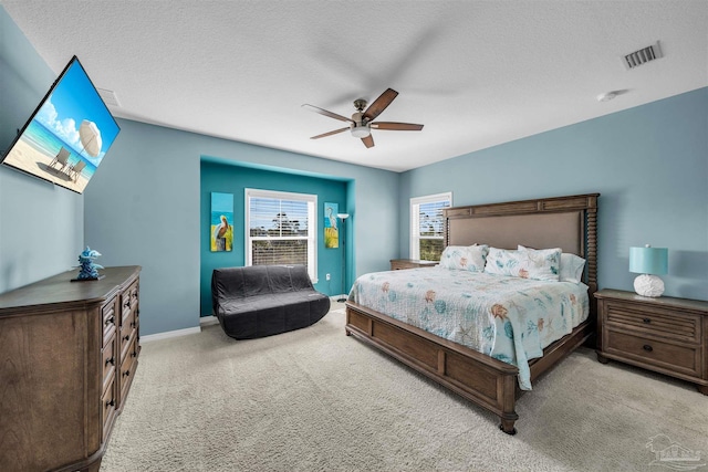 carpeted bedroom with ceiling fan and a textured ceiling