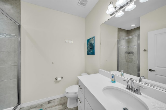 bathroom with toilet, hardwood / wood-style floors, vanity, and walk in shower