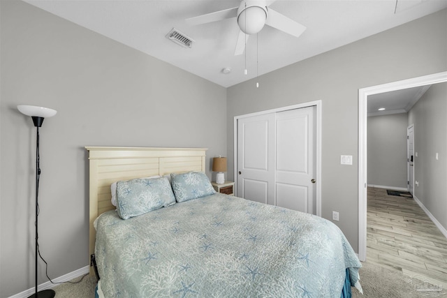 bedroom featuring ceiling fan, a closet, and light hardwood / wood-style flooring