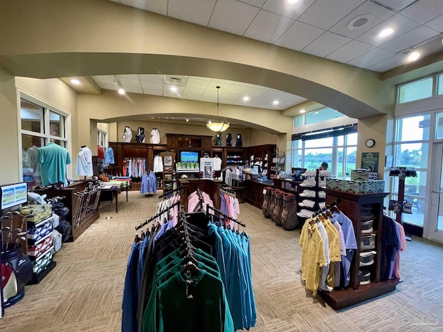 interior space with a drop ceiling and light colored carpet