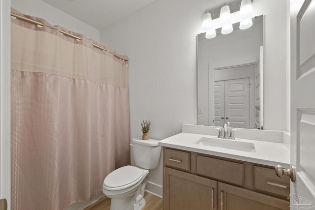 bathroom with a shower with curtain, hardwood / wood-style floors, vanity, and toilet