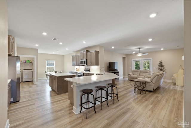 kitchen featuring light hardwood / wood-style floors, a kitchen bar, stainless steel appliances, and french doors