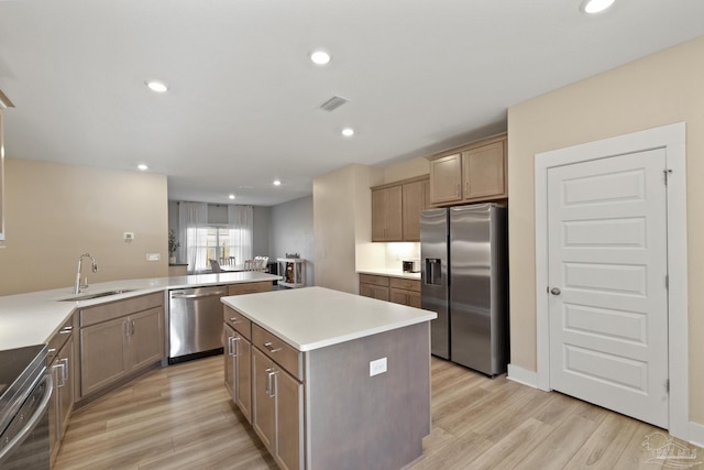 kitchen featuring sink, stainless steel appliances, light hardwood / wood-style flooring, kitchen peninsula, and a kitchen island