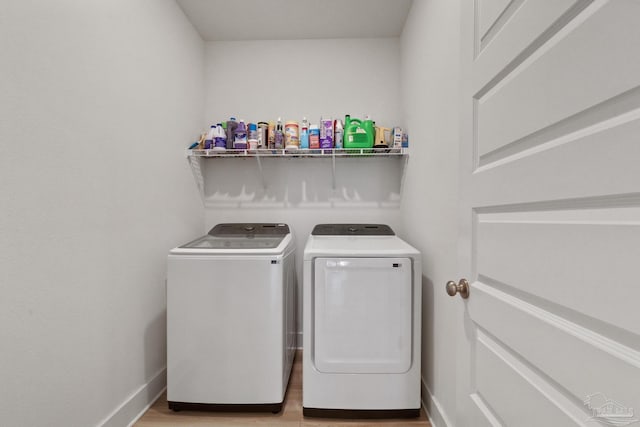 laundry room featuring light hardwood / wood-style flooring and washing machine and clothes dryer