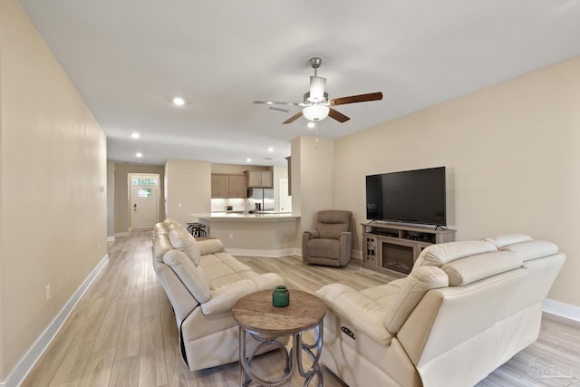 living room featuring ceiling fan and light hardwood / wood-style floors