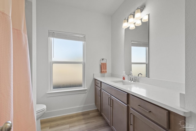 bathroom with hardwood / wood-style floors, vanity, and toilet