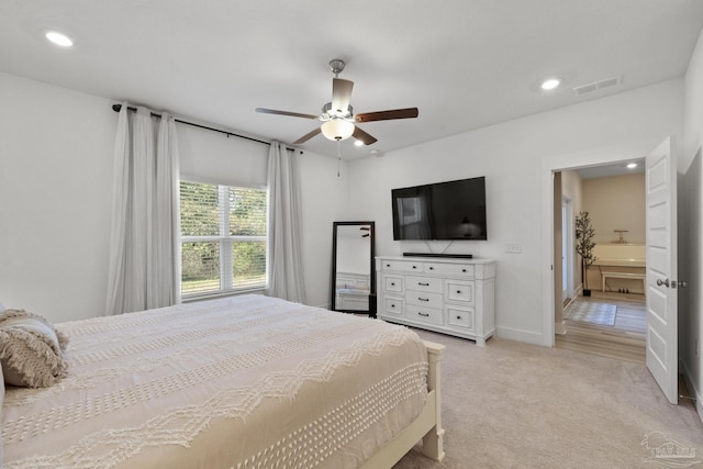 carpeted bedroom with connected bathroom and ceiling fan