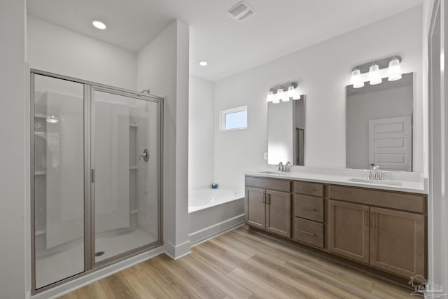 bathroom with separate shower and tub, hardwood / wood-style floors, and vanity