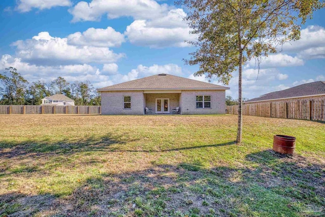 rear view of house featuring a yard