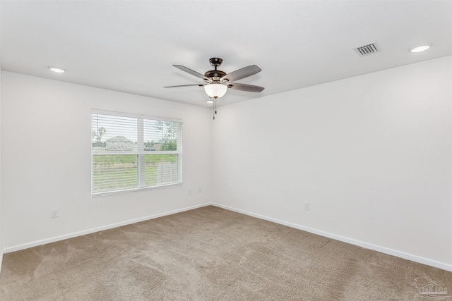 carpeted spare room featuring ceiling fan