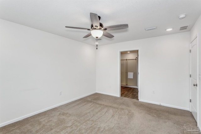 carpeted spare room featuring ceiling fan