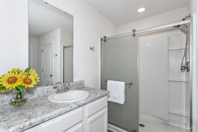 bathroom with vanity and a shower with shower door