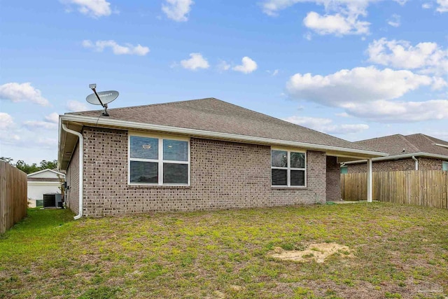 rear view of house with a lawn and cooling unit