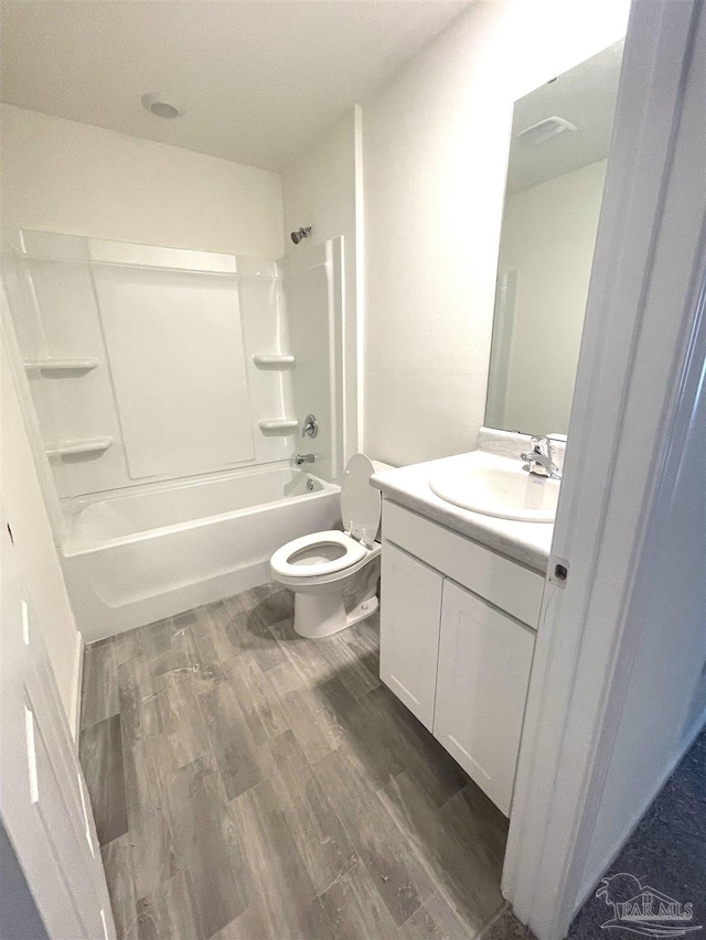 bathroom with toilet, vanity, bathtub / shower combination, and wood finished floors