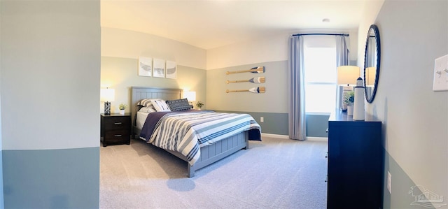 bedroom with baseboards and light colored carpet