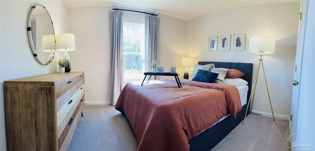 bedroom featuring light colored carpet and baseboards