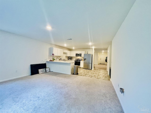 kitchen with a peninsula, stainless steel appliances, white cabinets, light carpet, and open floor plan