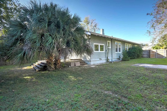 rear view of house featuring a lawn