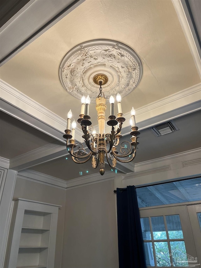 interior details with a notable chandelier, built in shelves, and ornamental molding