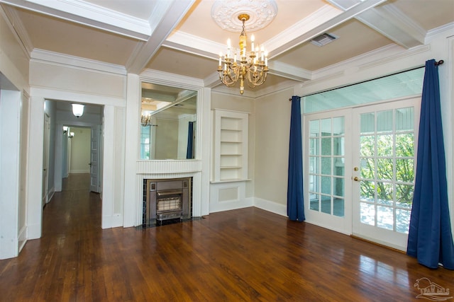 unfurnished living room featuring a notable chandelier, ornamental molding, built in features, and french doors