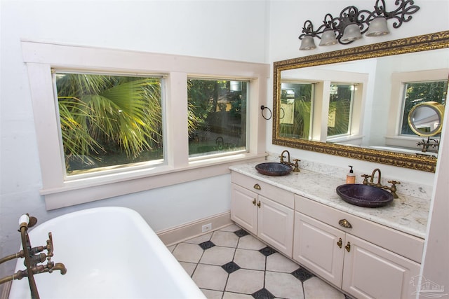 bathroom with a bathing tub, a healthy amount of sunlight, and vanity