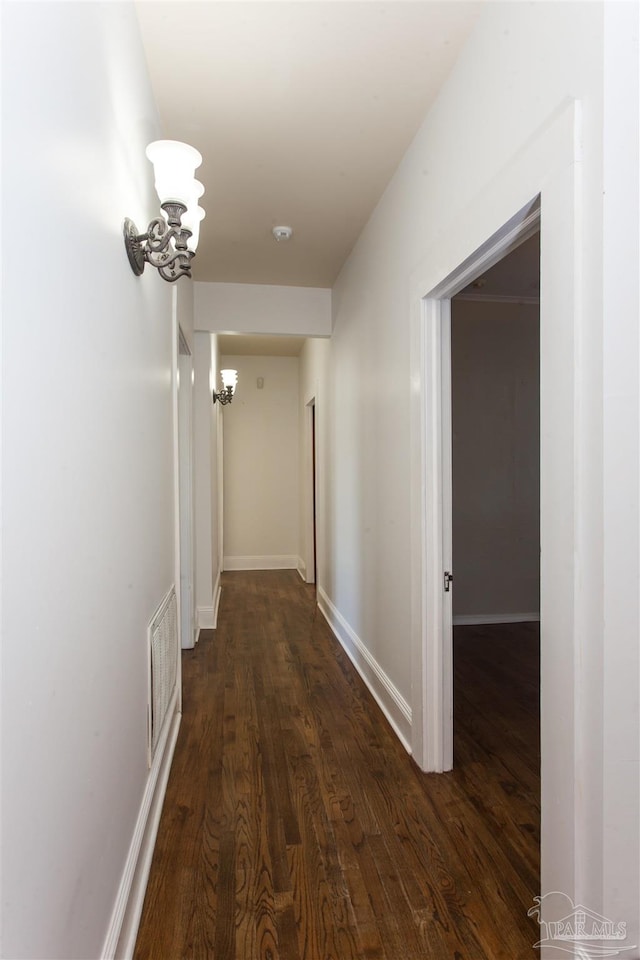 hall featuring dark hardwood / wood-style floors and an inviting chandelier