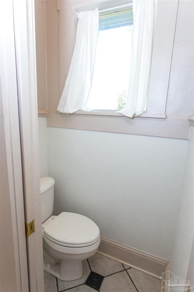 bathroom with toilet and tile patterned flooring