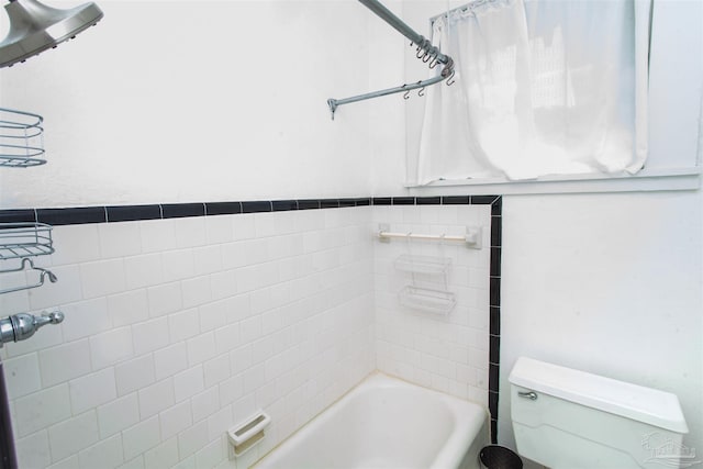 bathroom with tiled shower / bath and toilet