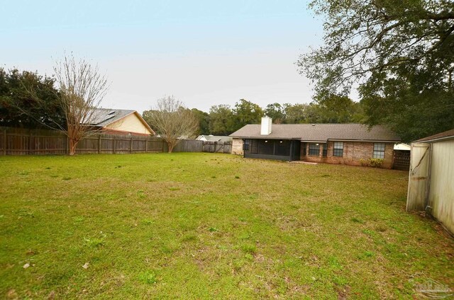 view of yard featuring a fenced backyard and a sunroom
