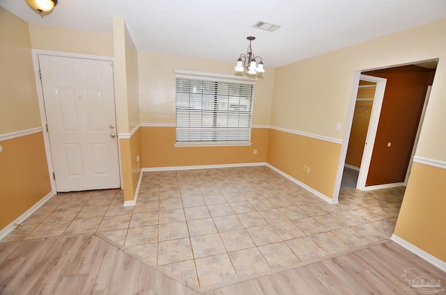 interior space featuring visible vents, baseboards, and an inviting chandelier