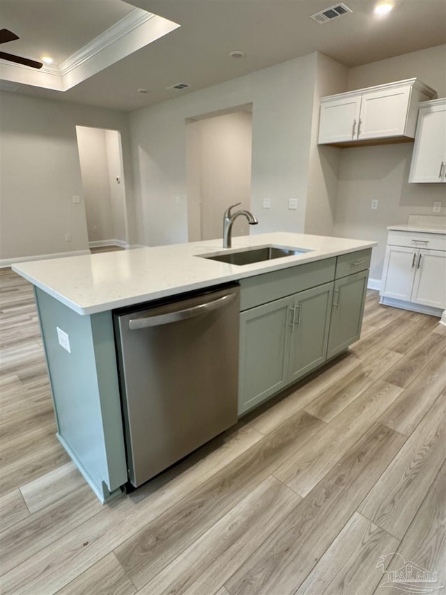 kitchen featuring sink, white cabinets, a kitchen island with sink, stainless steel dishwasher, and a raised ceiling