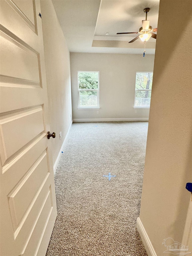 carpeted empty room featuring ceiling fan and a wealth of natural light