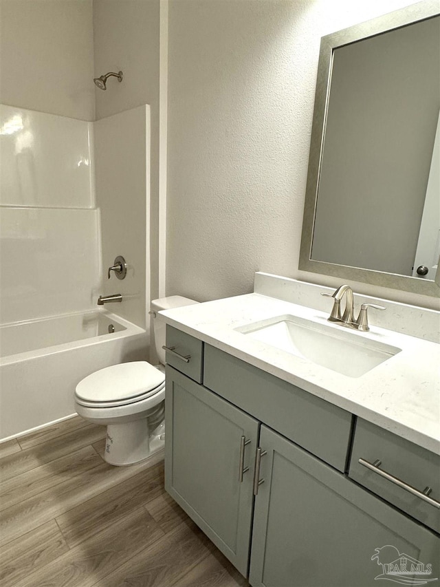 full bathroom featuring vanity, tub / shower combination, hardwood / wood-style floors, and toilet