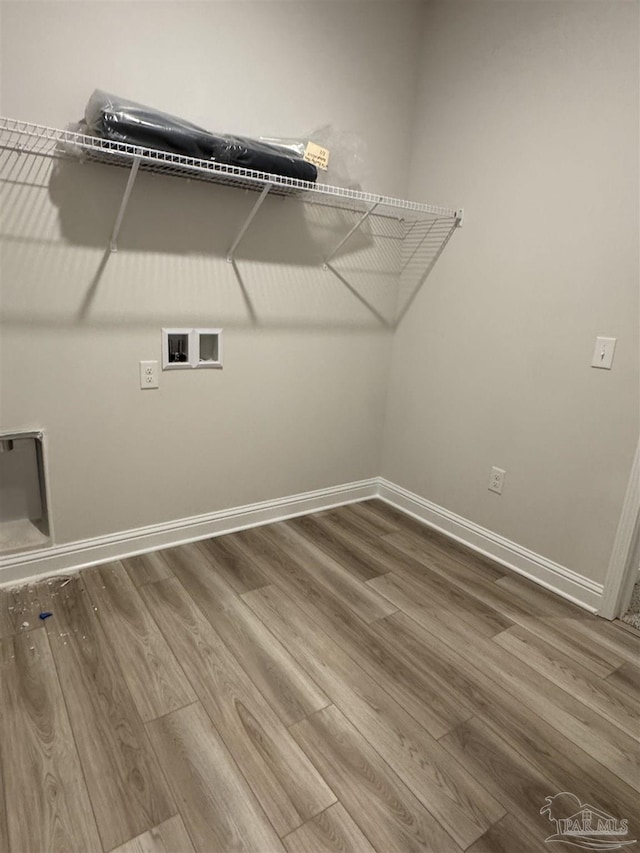 clothes washing area with hardwood / wood-style floors and hookup for a washing machine